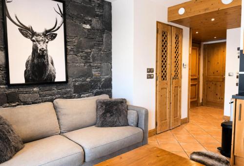 a living room with a couch and a picture of a deer at Chalet Adele - Appartement 4 personnes situé en bord de piste St Martin de Belleville MAE-5684 in Saint-Martin-de-Belleville