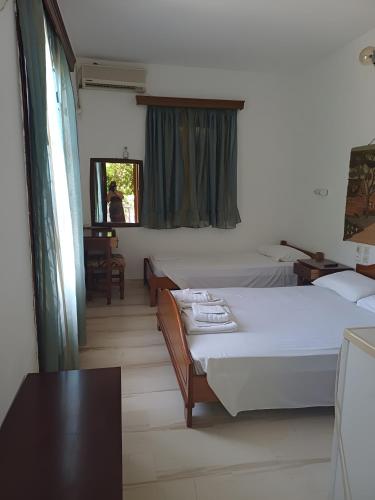ein Schlafzimmer mit zwei Betten, einem Tisch und einem Fenster in der Unterkunft Orama in Vasiliká