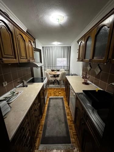 a kitchen with wooden cabinets and a table in it at TAMARIS Apartment in Subotica