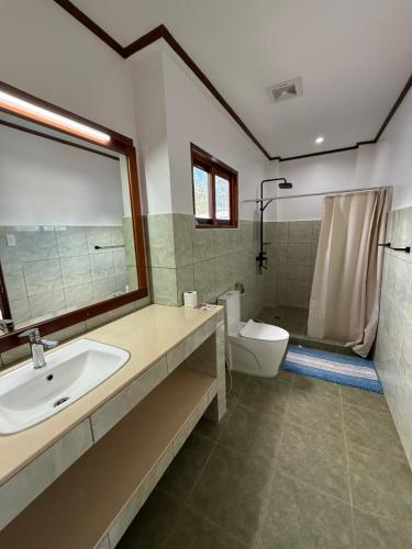a bathroom with a sink and a toilet and a shower at Takbo Beach Resort in General Luna