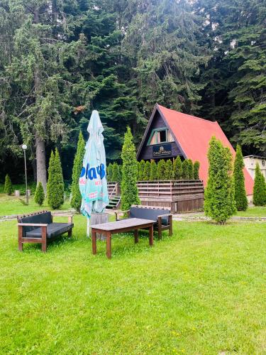 a group of benches in a field with a house at Chalet Musala in Borovets