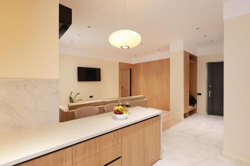 a kitchen with a counter and a living room at PANA Apartments in Nukus