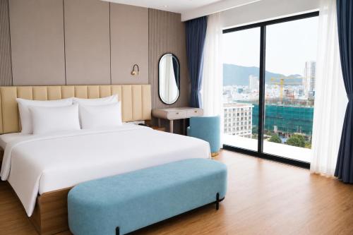 a bedroom with a large bed and a large window at The Golden Crest Hotel Quy Nhon in Quy Nhon