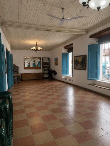 a large room with a checkered floor and blue windows at Hostal Casona de los Vega in Sonsonate