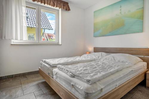 a bed in a bedroom with a large window at Haus U13 in Röbel
