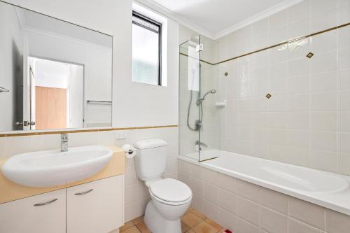a white bathroom with a sink and a toilet at Coolum Beach Apartment, 2 Bed 2 Bath, Pool in Coolum Beach