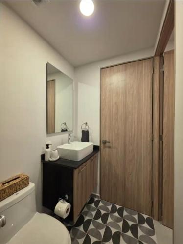 a bathroom with a toilet and a sink and a mirror at Villadhara Centro GDL in Guadalajara