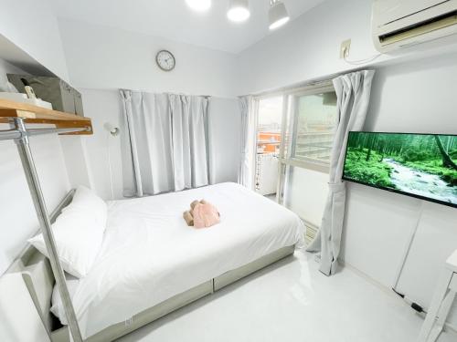 a small bedroom with a bed and a flat screen tv at Kameari 911 - 9F Newly Renovated Corner Room High Floor Near Station Mall Disney Access in Tokyo