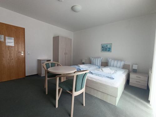 a bedroom with a bed and a table and chairs at Gästehaus St Markus in Höxter