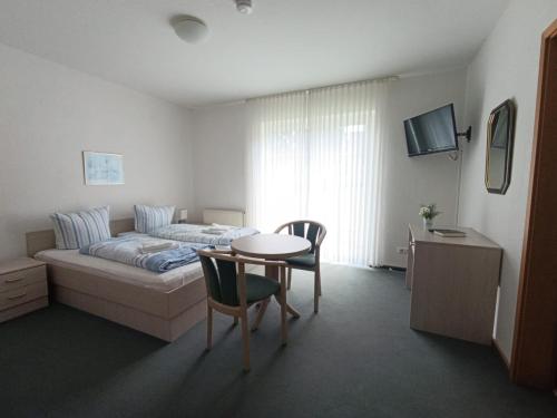 a bedroom with a bed and a table and chairs at Gästehaus St Markus in Höxter