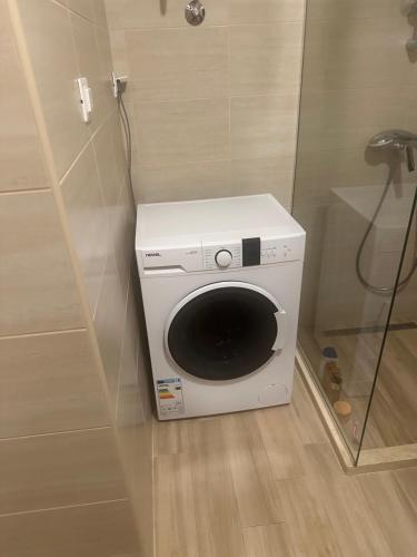 a washing machine in the corner of a bathroom at AB LUX Apartmani 406 in Sutomore