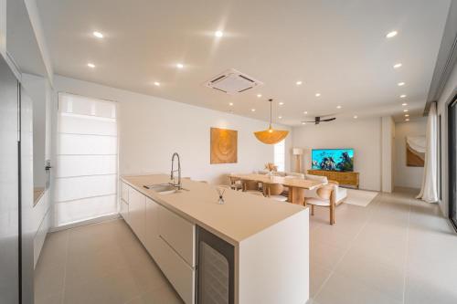 a kitchen with a table and a dining room at Valentine Village in Choeng Mon Beach