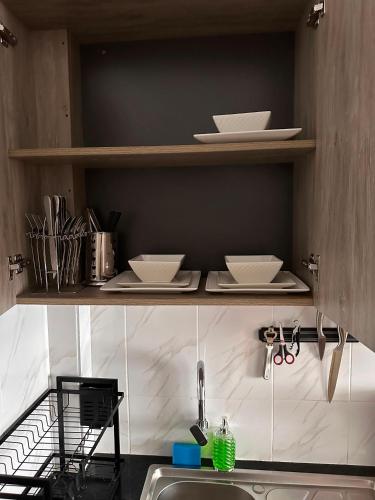 a kitchen with plates and bowls on shelves above a sink at Homes by Sil Bn in Muchatha