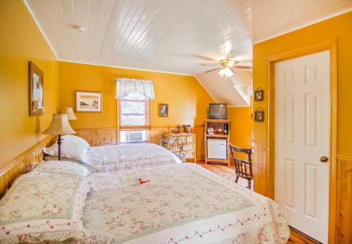 a bedroom with a large bed and yellow walls at Auberge Au Soleil Levant in Piopolis