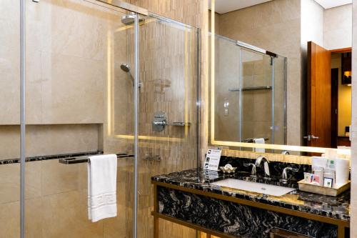 a bathroom with a sink and a shower at Coron Westown Resort in Coron