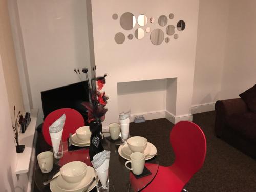 a living room with a table with red chairs at Fantastic House with Amenities in Hull