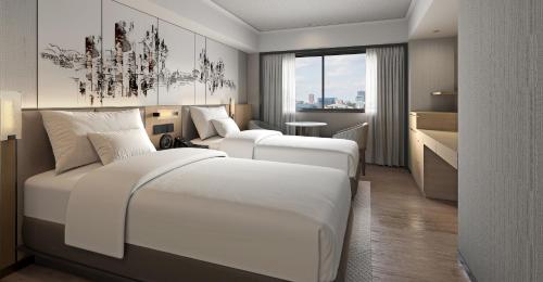 a hotel room with two beds and a chandelier at Hotel Pearl City Kobe in Kobe