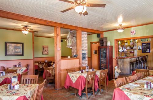 un restaurant avec des tables, des chaises et des tissus de table roses dans l'établissement Auberge Au Soleil Levant, à Piopolis