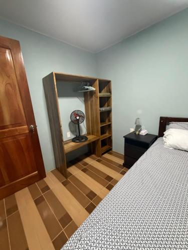 a bedroom with a bed and a wooden closet at Lugar de paz cerca de Upala in Upala
