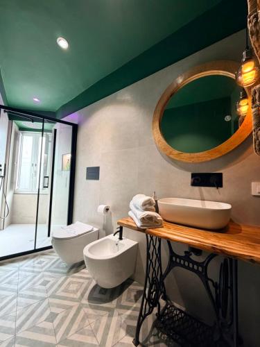 a bathroom with a sink and a toilet and a mirror at Le Tartarughe - Rooms and Apartments - in Milazzo