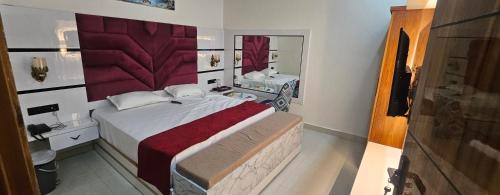 a bedroom with a large bed and a mirror at The Eros in Sonīpat