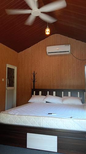 a bedroom with a bed with a ceiling fan at Chill Hutz in Vedakudiyiruppu