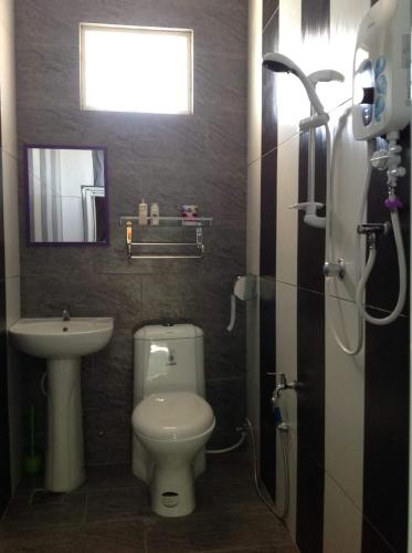 a bathroom with a toilet and a sink at Villa Sri Tebengau in Kuah