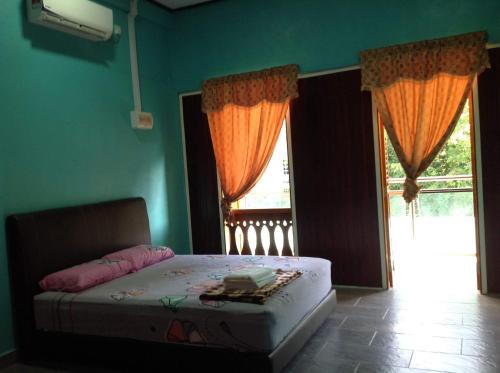 a bedroom with a bed and a large window at Villa Sri Tebengau in Kuah