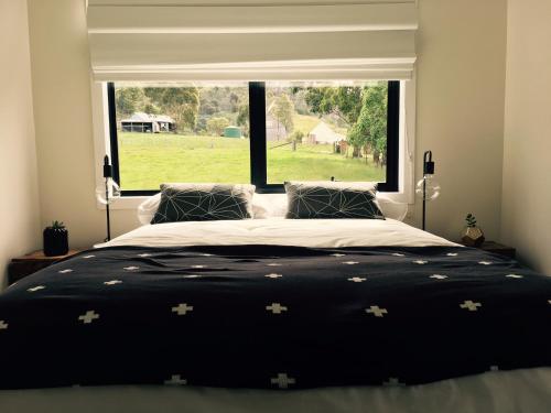 a bedroom with a large bed with a large window at Twamley Farm in Buckland