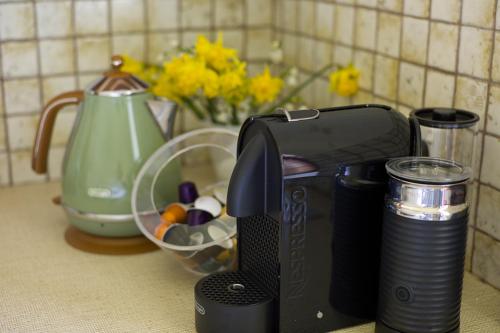 a toaster sitting on a counter next to a vase of flowers at The Storekeeper's in Buckland