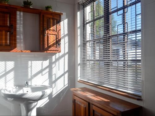 a bathroom with a white sink and a window at The Meadow Manor in Port Edward