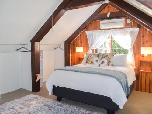 a bedroom with a large bed with a window at The Meadow Manor in Port Edward