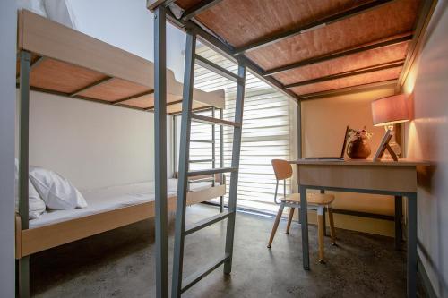 a bedroom with a bunk bed and a desk and a bunk bed at The Pad CoLiving in Cebu City