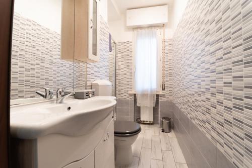 a white bathroom with a sink and a toilet at CASE VACANZE ROSA CON SERVIZIO SPIAGGIA in Lido Adriano