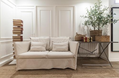 a white couch with pillows in a living room at Auditorio Rooms Boutique Oviedo in Oviedo