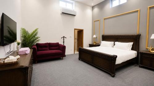 a bedroom with a large bed and a red chair at Royal Palm Villa in Rawalpindi