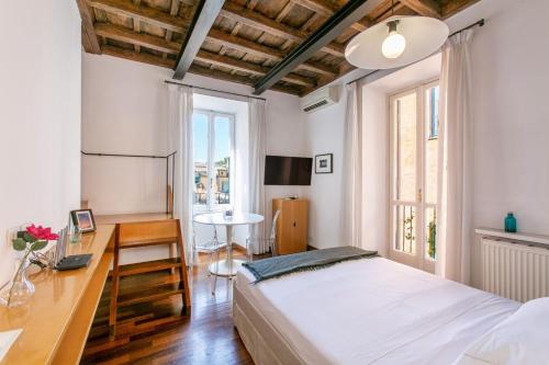 a bedroom with a bed and a desk and a table at Rome Central Suite via Vittoria in Rome