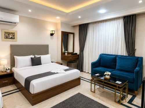 a hotel room with a bed and a blue couch at Egypt Aziz pyramids in Cairo