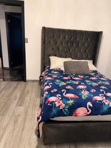 a bed with a bedspread with flamingos on it at Cabaña Lakshmi in El Pescador