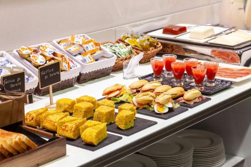 a buffet with sandwiches and drinks and other food at Sercotel Hola Tafalla in Tafalla