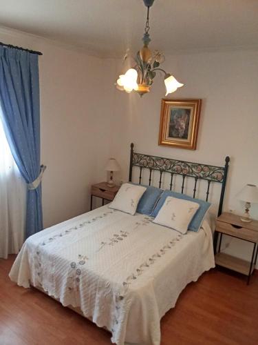 a bedroom with a large bed with blue curtains at Valencia Casa Rosa in Sedaví