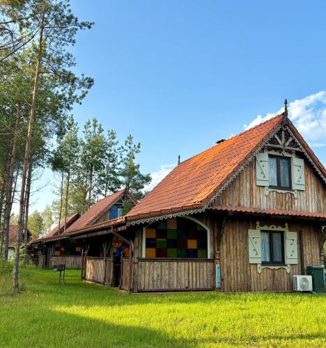 a wooden house with a red roof at Siedlisko Konradówka in Olecko