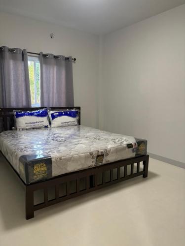 ein Bett in einem weißen Zimmer mit einem Bettgestell in der Unterkunft Mini House in Koh Samui 