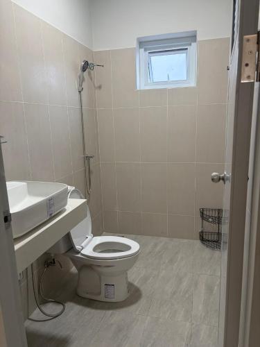 ein Badezimmer mit Toilette, Waschbecken und Fenster in der Unterkunft Mini House in Koh Samui 
