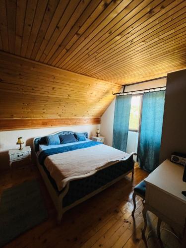 a bedroom with a large bed with a wooden ceiling at Meandri Ćehotine in Pljevlja