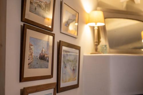 a group of pictures on a wall with a lamp at The Dogbox, Karen in Nairobi