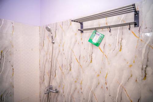a bathroom with a shower with a marble wall at SANS Vibes Violeta Inn Jambi in Jambi