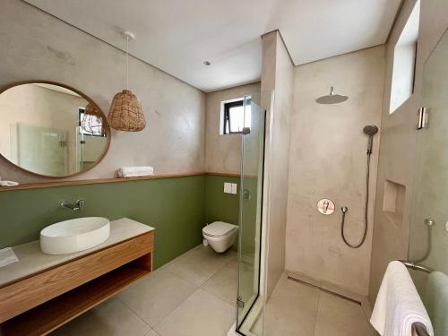 a bathroom with a shower and a toilet and a mirror at Exclusive beachfront penthouse in Belle Mare