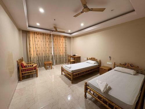 a bedroom with two beds and a ceiling fan at Iskcon guest house in Patna