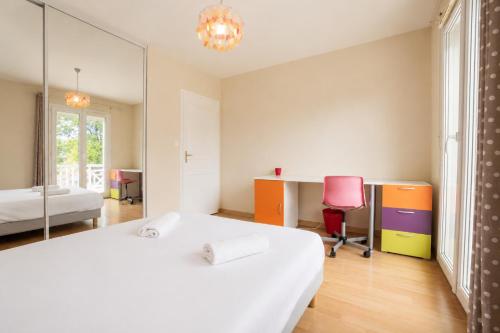 a bedroom with a white bed and a pink chair at L'Horizon des Chênes - grand jardin, bbq & table de ping pong in Hagetmau